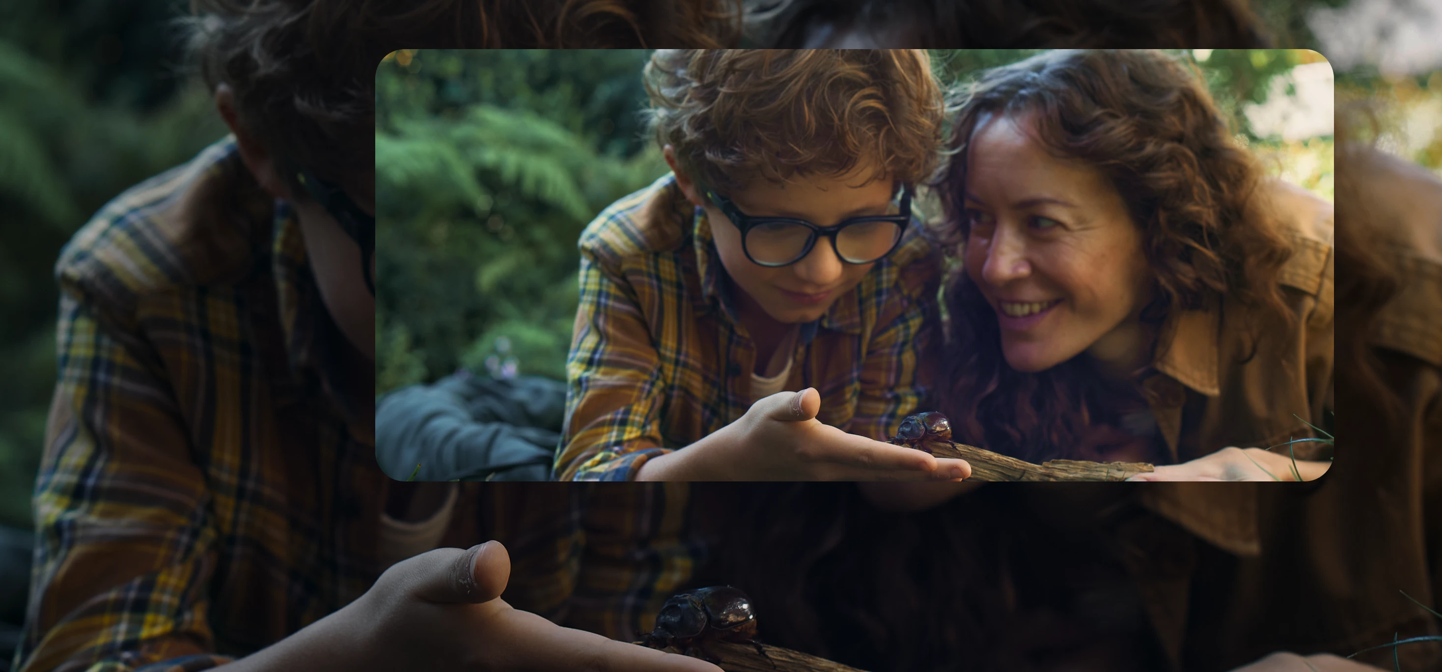 A mother and her son outdoors observing a beetle