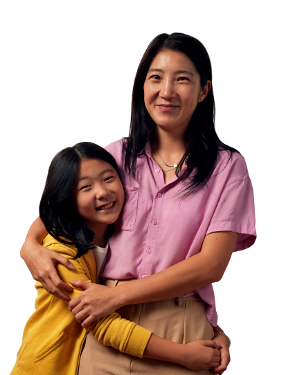 A mother wrapping her arms around her daughter and both are smiling